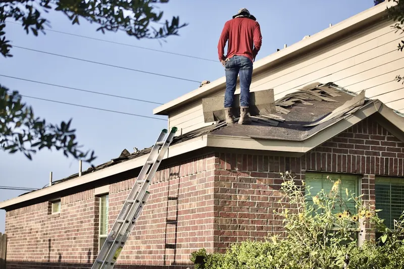 Professional roofer working on a residential roof in Junction City